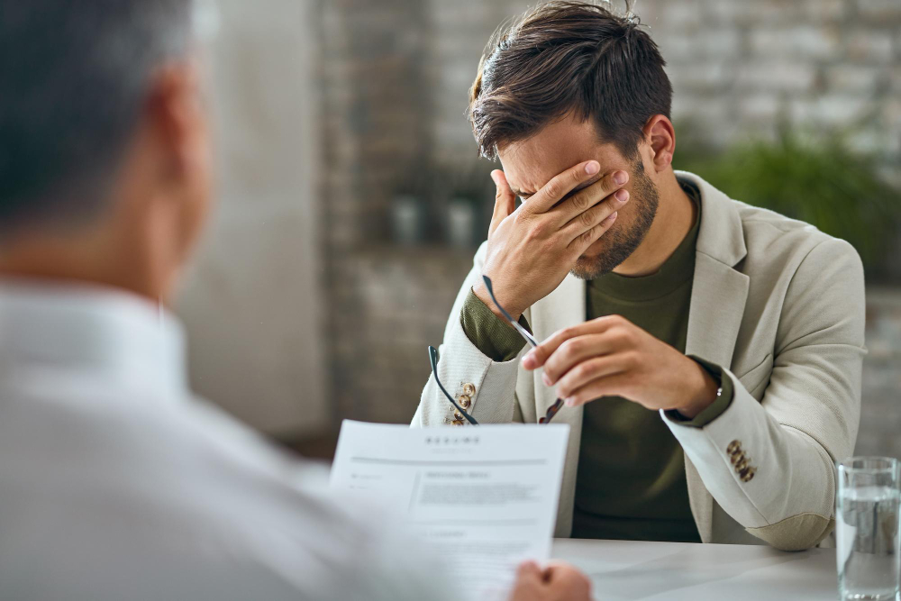 Worried male candidate having a job interview with a manager in the office