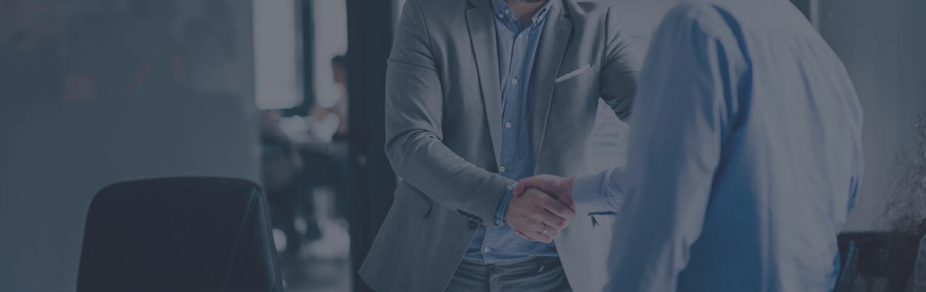 People in suits shaking hands in meeting